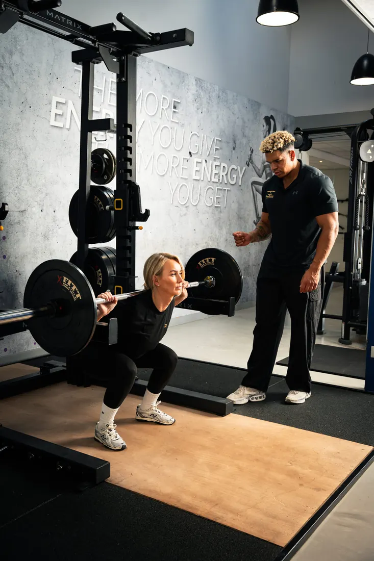Personal trainer van GE Coaching begeleidt een squat bij Go4Fit Heesch