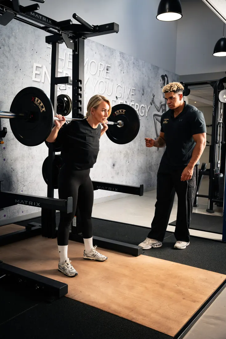 Barbell squat met personal trainer
